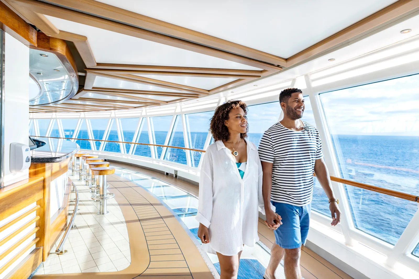 Couple walking the SkyWalk glass-floor walkway cantilevered over the ocean on Princess Cruises